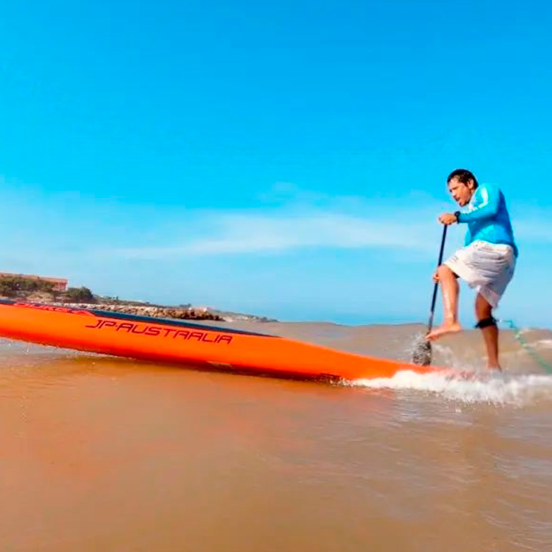 Cristian Almonacid remando entre las olas.